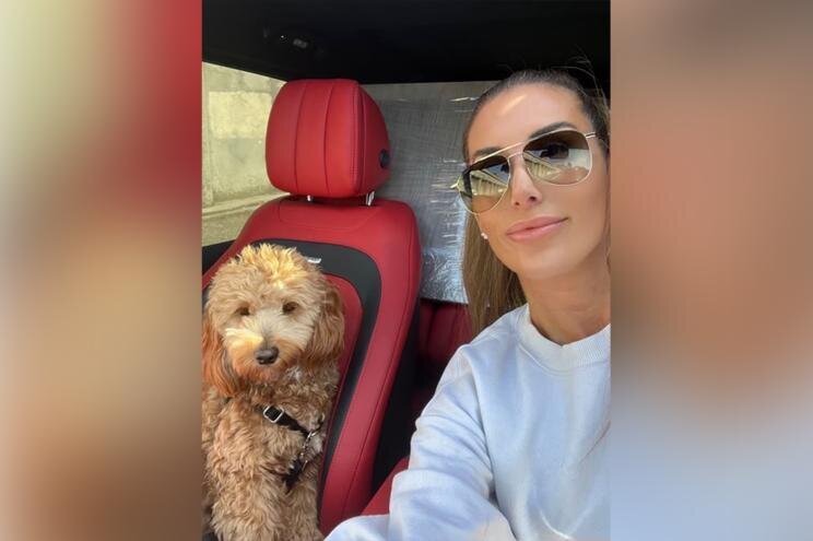 یک زن با عینک آفتابی در کنار سگش