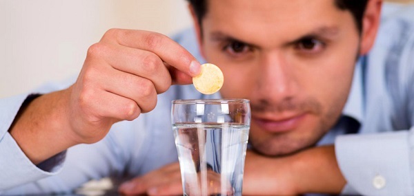 مردی در حال انداختن قرص منیزیوم داخل لیوان
