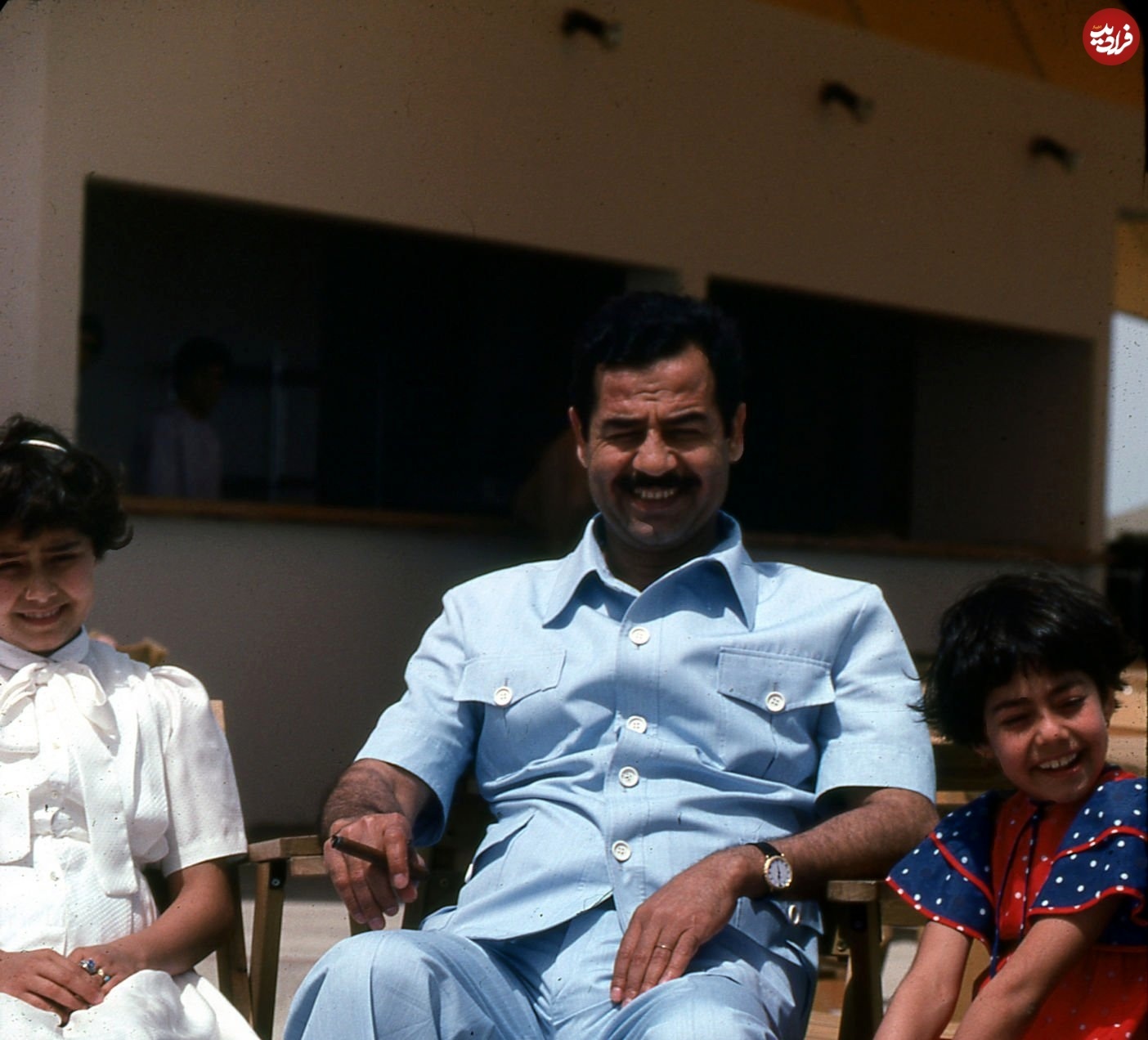 صدام در حال سیگار کشیدن میان فرزندان اش