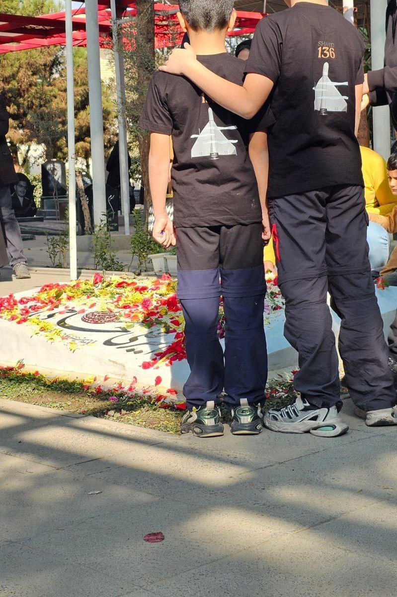 تیشرت دو پسر بر مزار سردار حاجی‌زاده