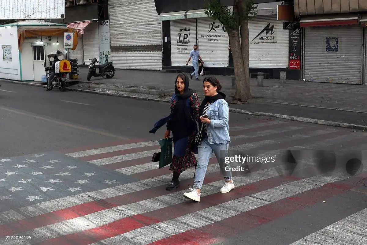 عبور از روی نقاشی پرچم آمریکا و اسرائیل در جنوب تهران