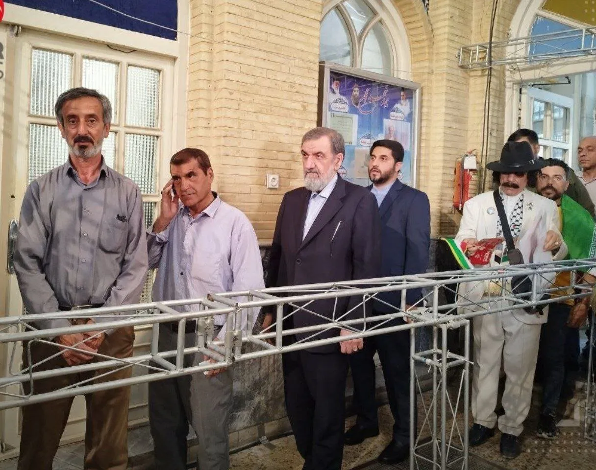 عکس/استایل عجیب یک شهروند پشت سر محسن رضایی در صف انتخابات