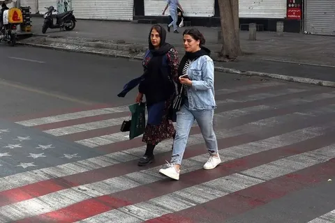 عبور از روی نقاشی پرچم آمریکا و اسرائیل در جنوب تهران