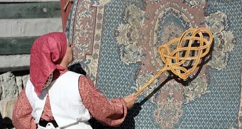 تصویری از تکاندن خاک قالی با چوب ۶۵ سال پیش در اصفهان